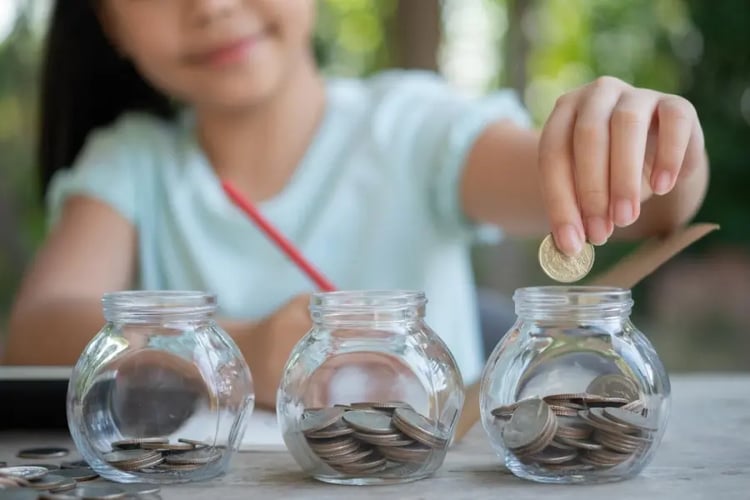 Jolie petite fille jouant avec des pièces de monnaie faisant des piles